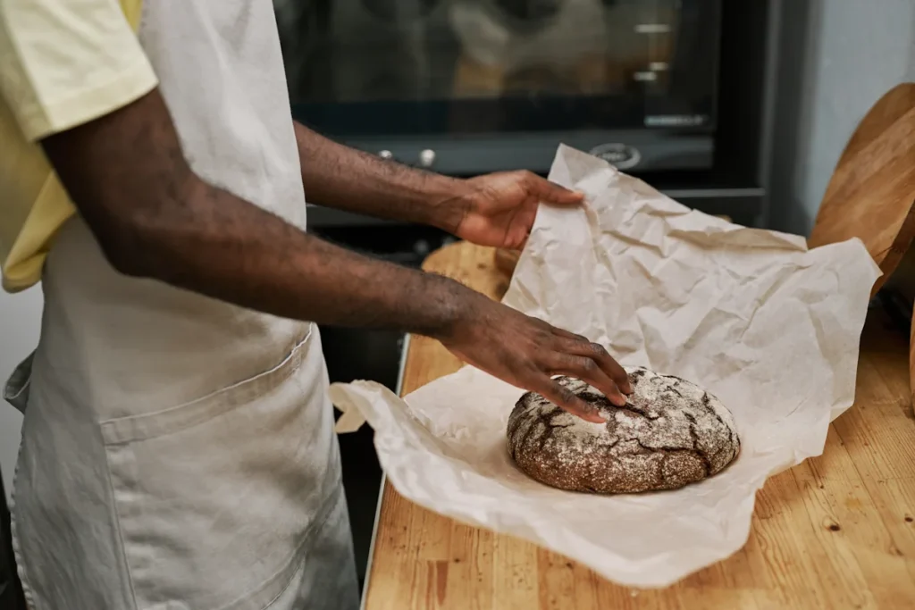 Un homme qui emballe du pain dans du papier alimentaire