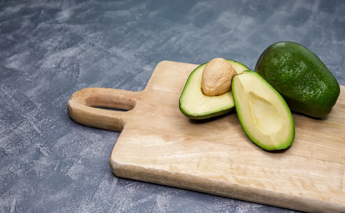 Avocat coupé en deux sur planche en bois pour illustrer l'avocat perte de poids