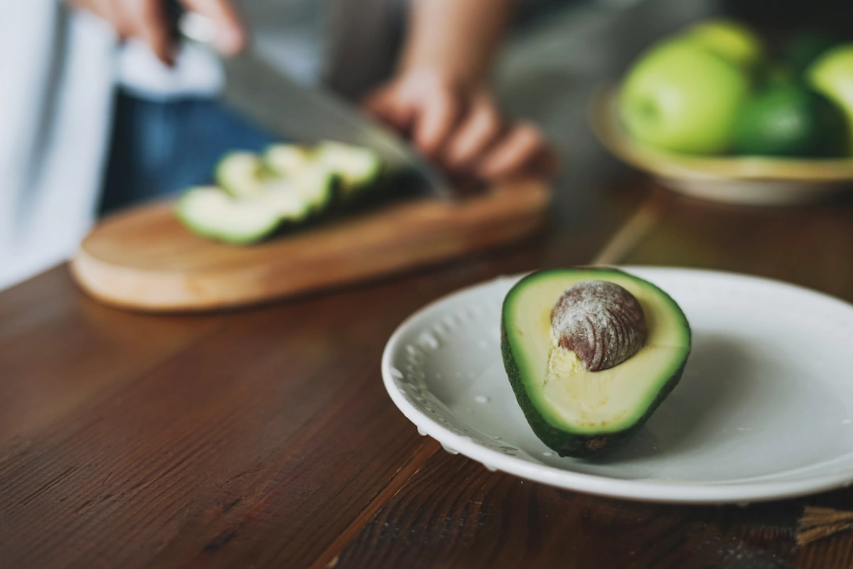 Portion d'un demi-avocat pour maigrir dans une assiette équilibrée avec légumes verts