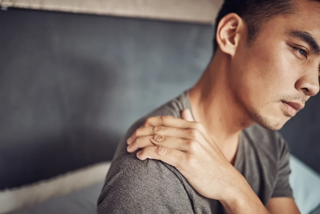 Un jeune homme qui se tient l'épaule