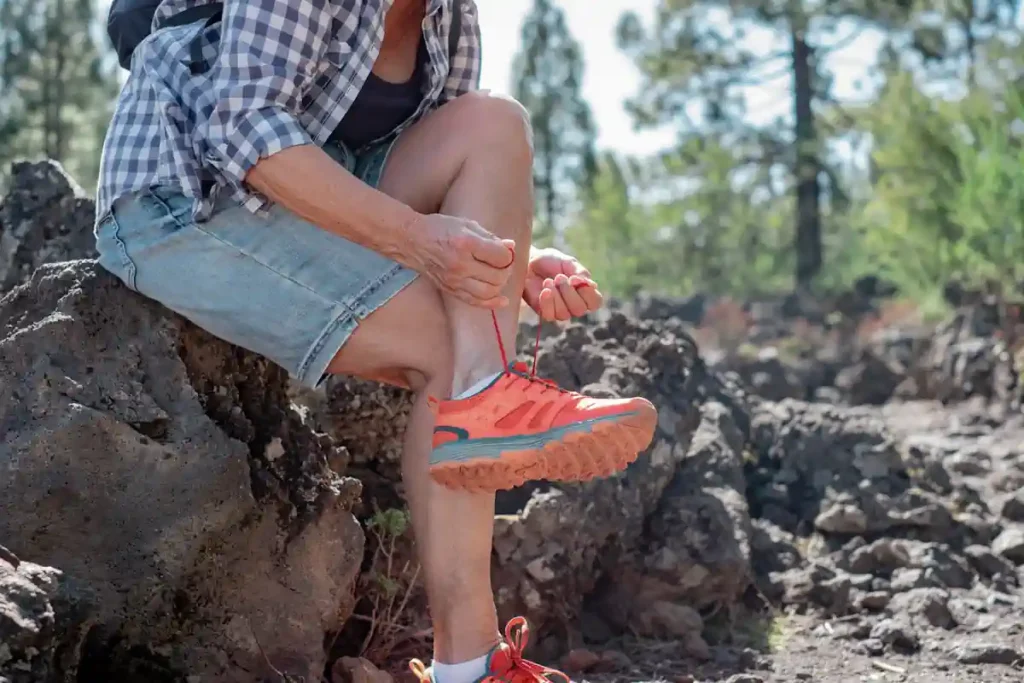 Une personne qui attache des chaussures oranges