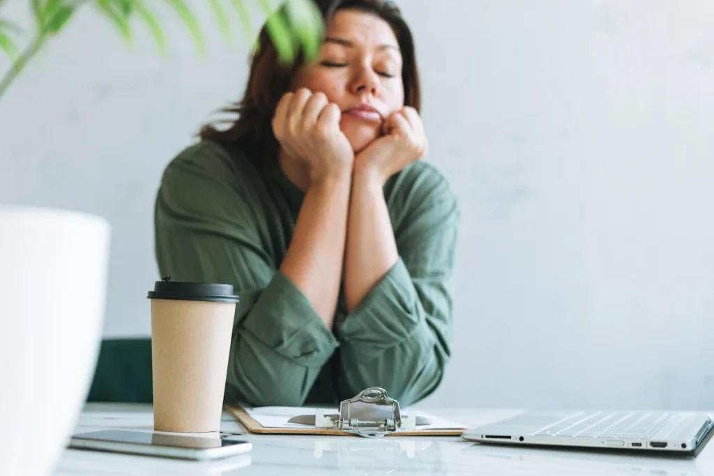 Une femme qui se tient la tête en fermant les yeux