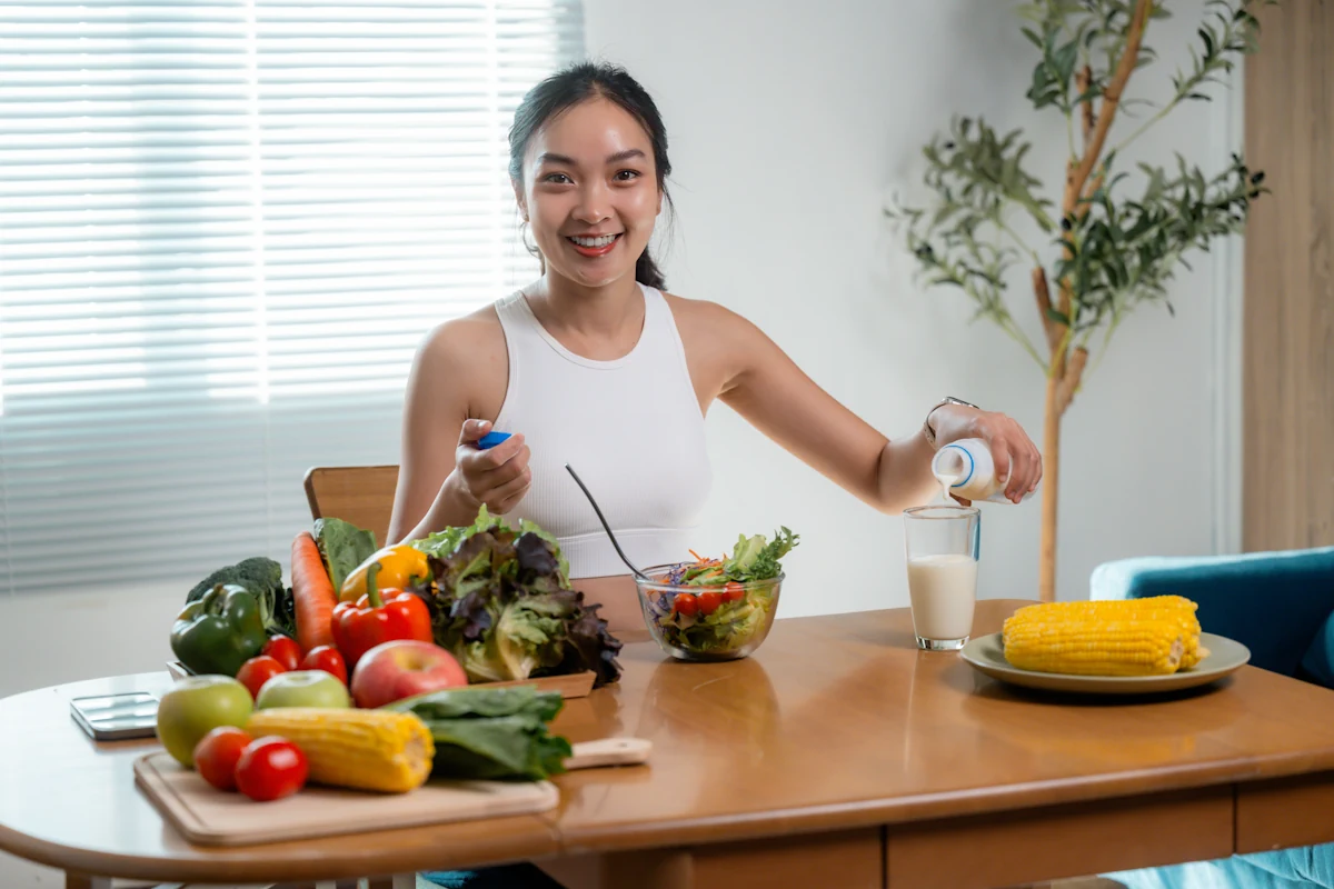 Une femme qui prépare une assiette sur une table où sont posés plusieurs ingrédients