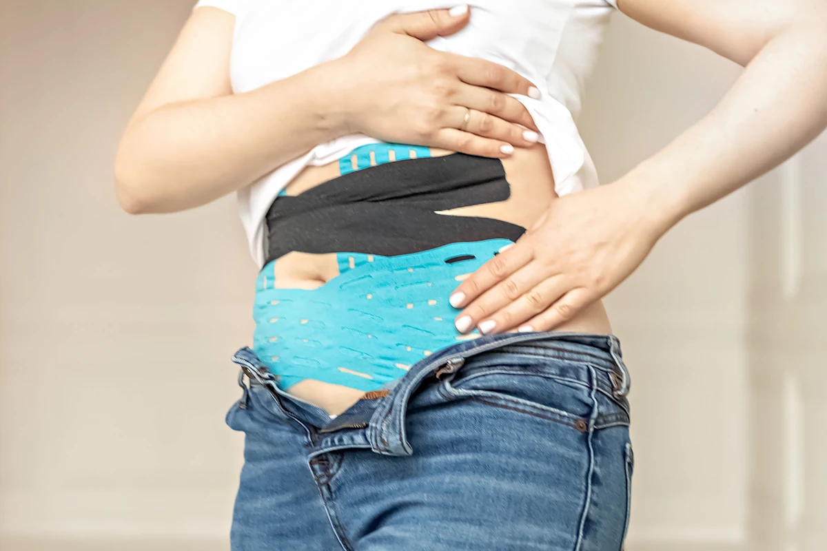 Une femme qui met des sangles sur le ventre