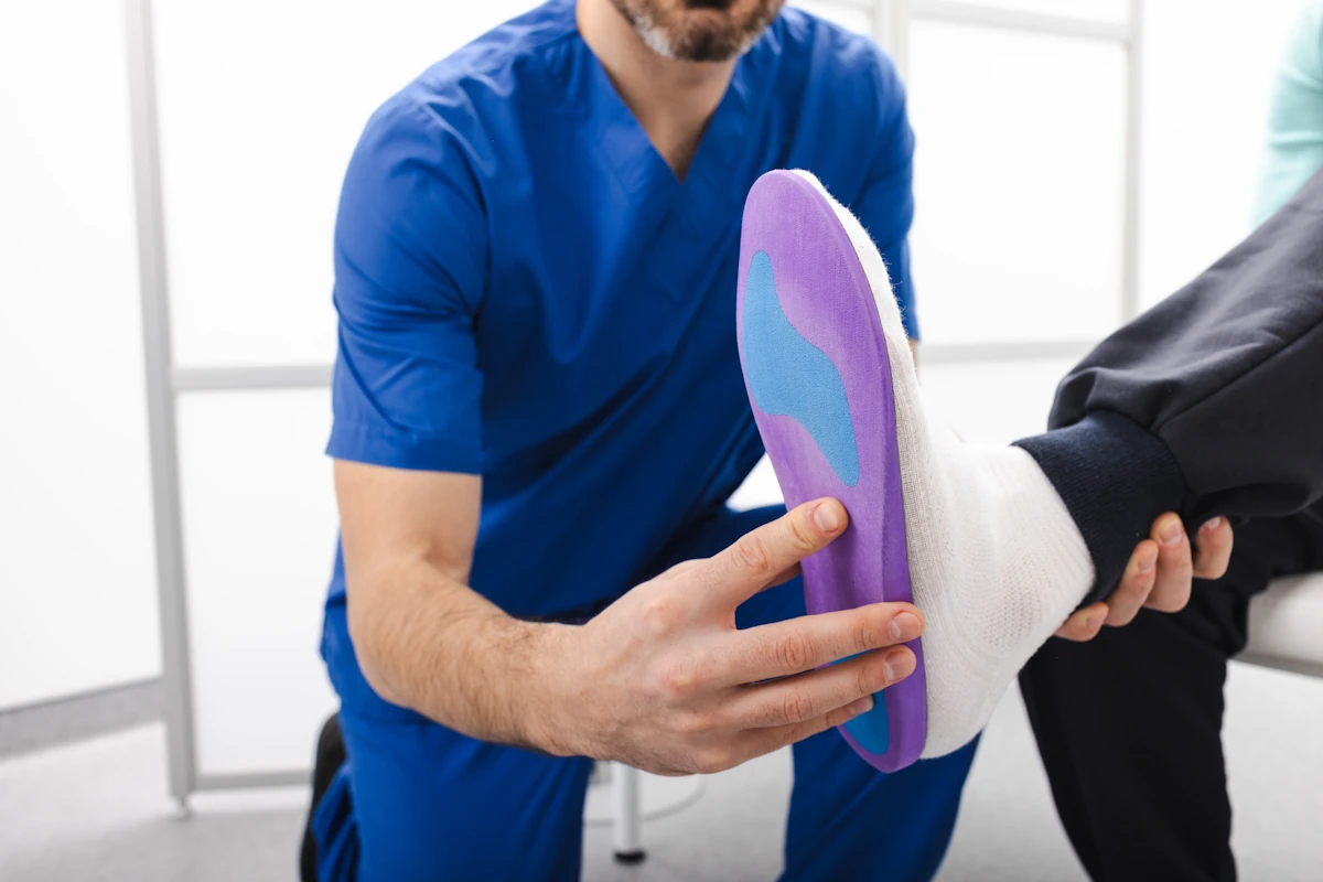 Un médecin qui conseille une semelle orthopédique à un patient